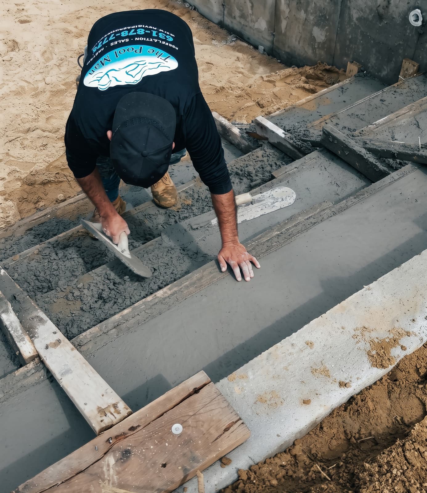 The Pool Man crew troweling concrete decking during a pool build